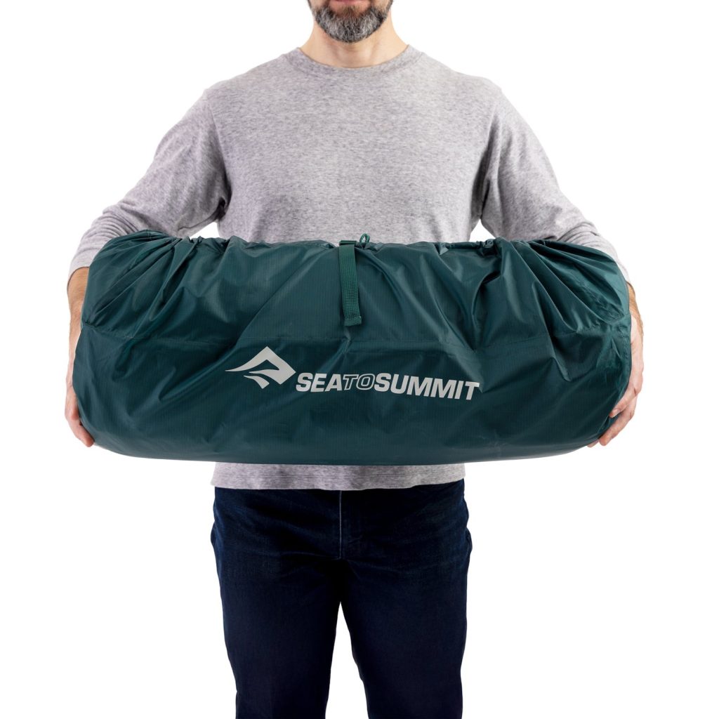 Sea to Summit Comfort Deluxe SI Double arrotolato nella sacca, tenuto in mano