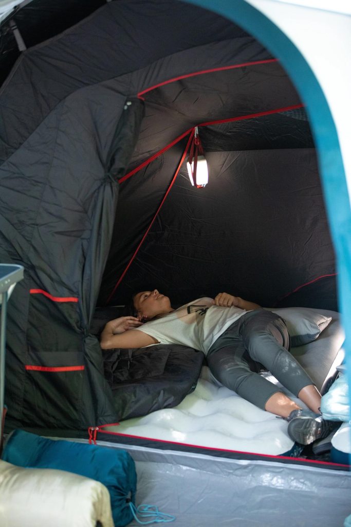 Due persone sdraiate su un Quechua Air Basic 140 in tenda