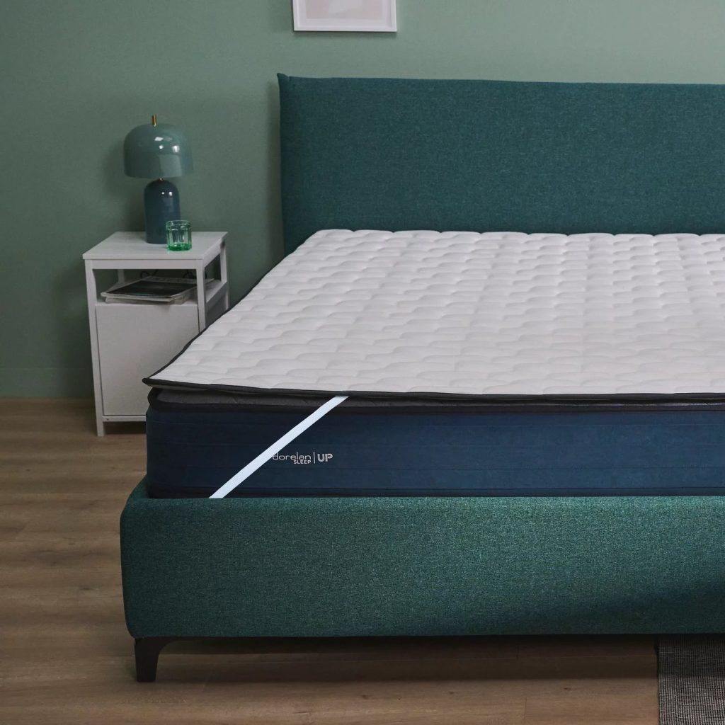 Dorelan Topper Up Fiber su un letto con testiera verde