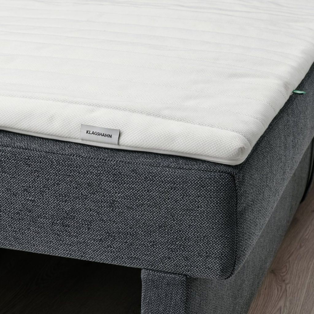 IKEA Klagshamn steso su un divano letto grigio, dettaglio dell'etichetta