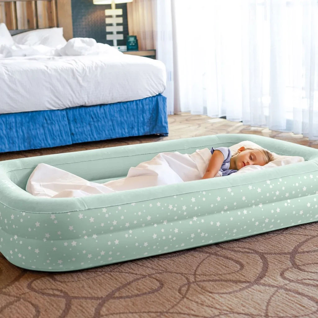 Bambina che dorme sull'Intex Travel Cozy Kidz accanto al letto in una camera d'albergo