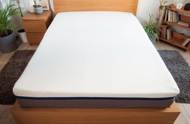 Materasso su letto in rovere visto dai piedi del letto