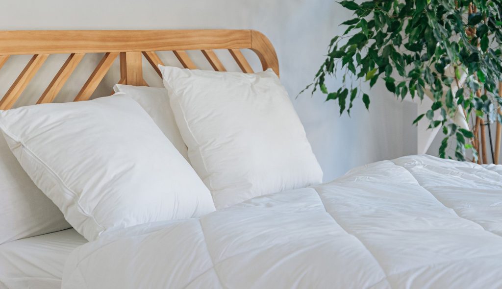 Slome Cuscini Ibridi su un letto con testiera in legno